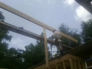 Carpenter setting a ridge beam over a new addition frame — Ice Dam Removal by Roofing Brothers in Powhatan Point