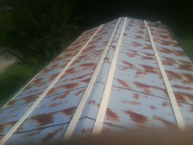 Rusted metal roof panels with new wood purlins before replacement — Storm Damage Roof Repair in Powhatan Point by Roofing Brothers