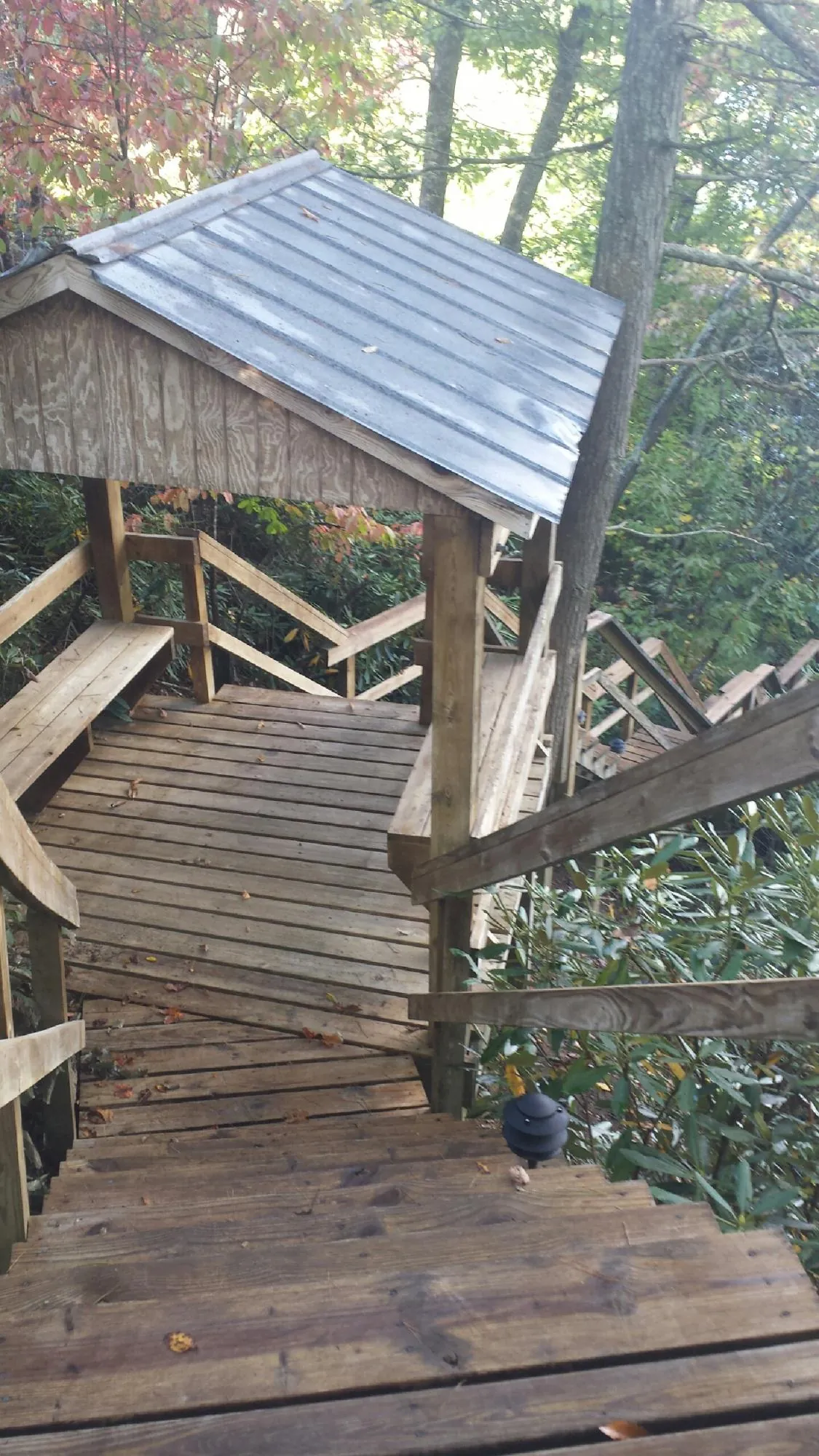 Metal roofed shelter over wooden steps on a wooded walkway — Skylight Repair & Installation work by our crew in Powhatan Point