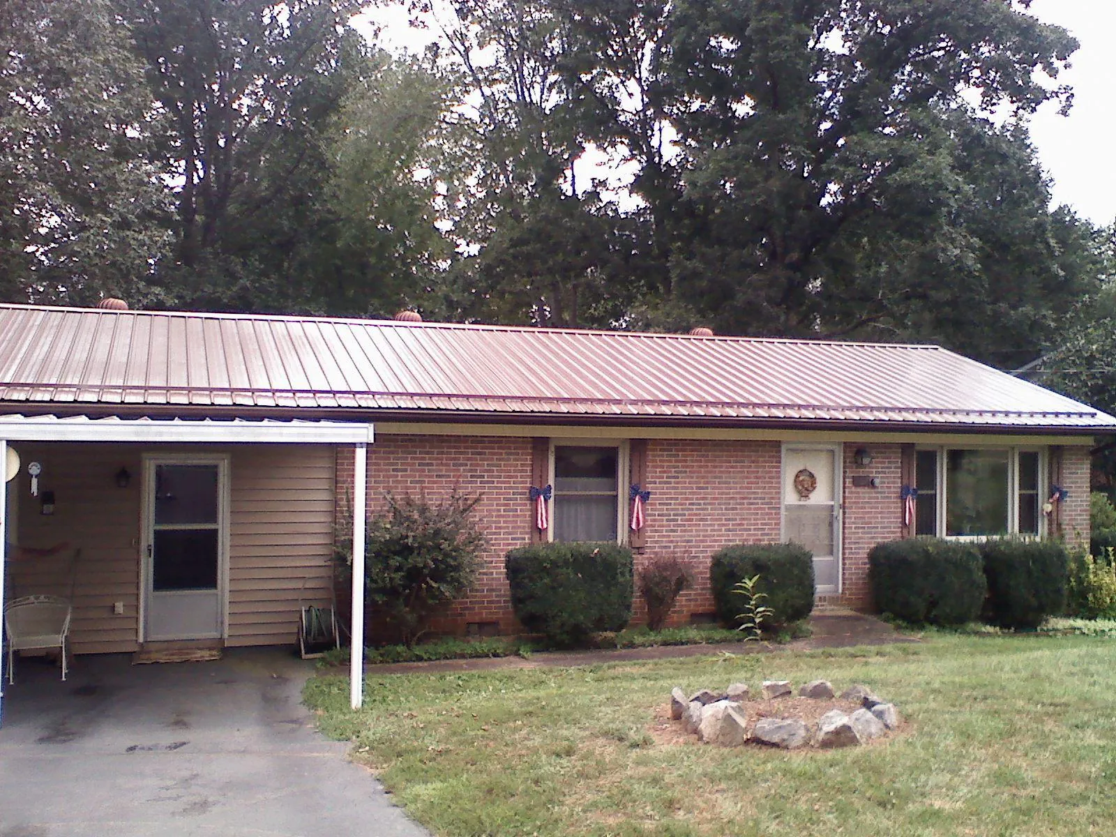 Bronze metal roof and carport on a brick ranch home — Roof Repair work by our crew in Powhatan Point
